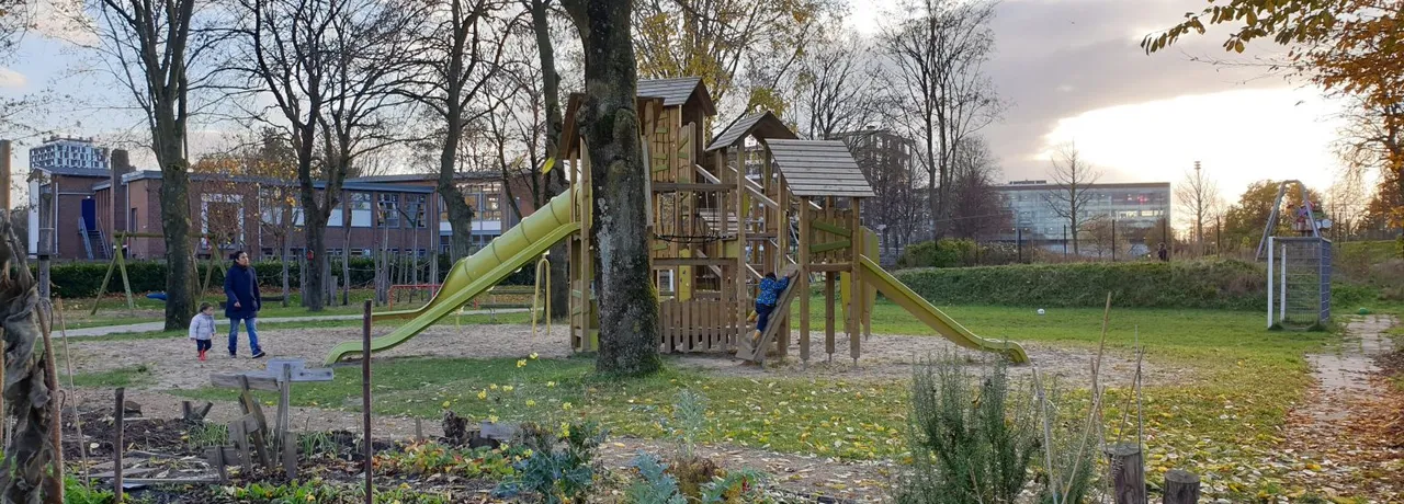 Kinderen spelen bij het klimtoestel met glijbanen in speeltuin Noordse Park