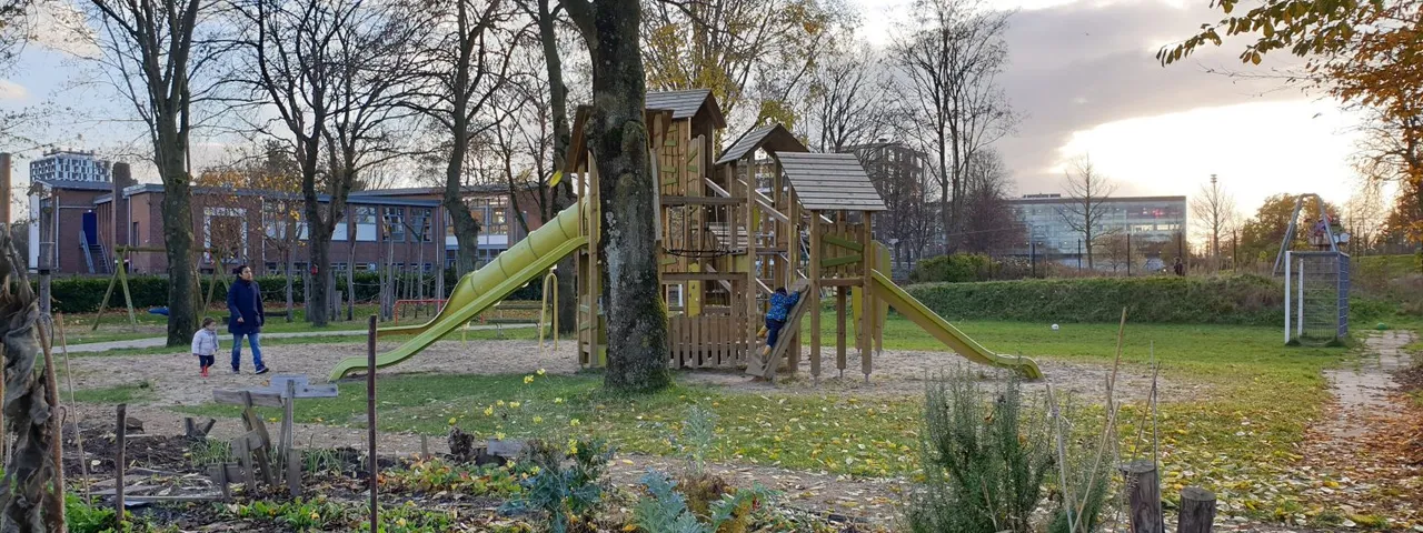 Kinderen spelen bij het klimtoestel met glijbanen in speeltuin Noordse Park